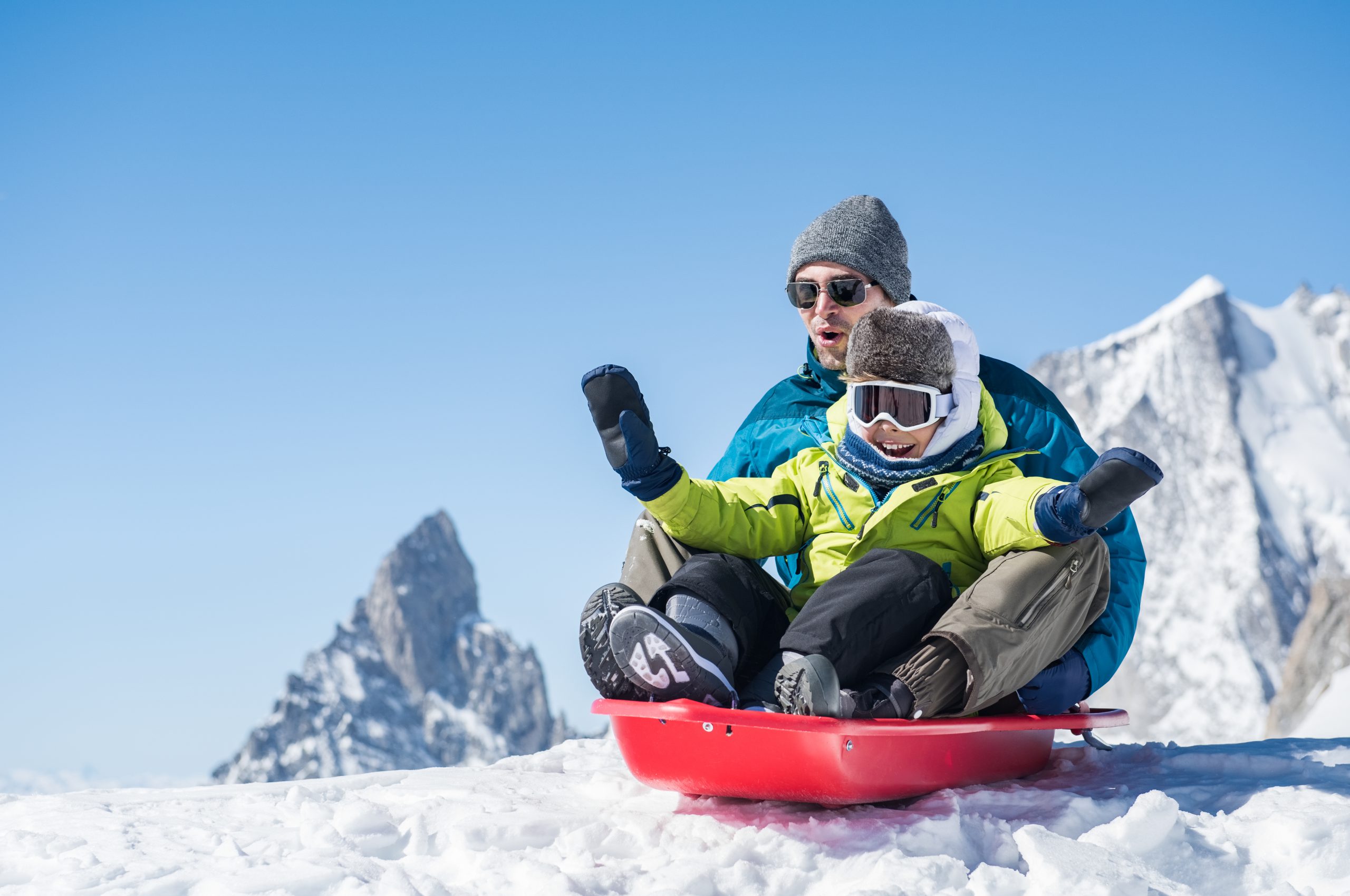 Father and son sledding or tobogganing