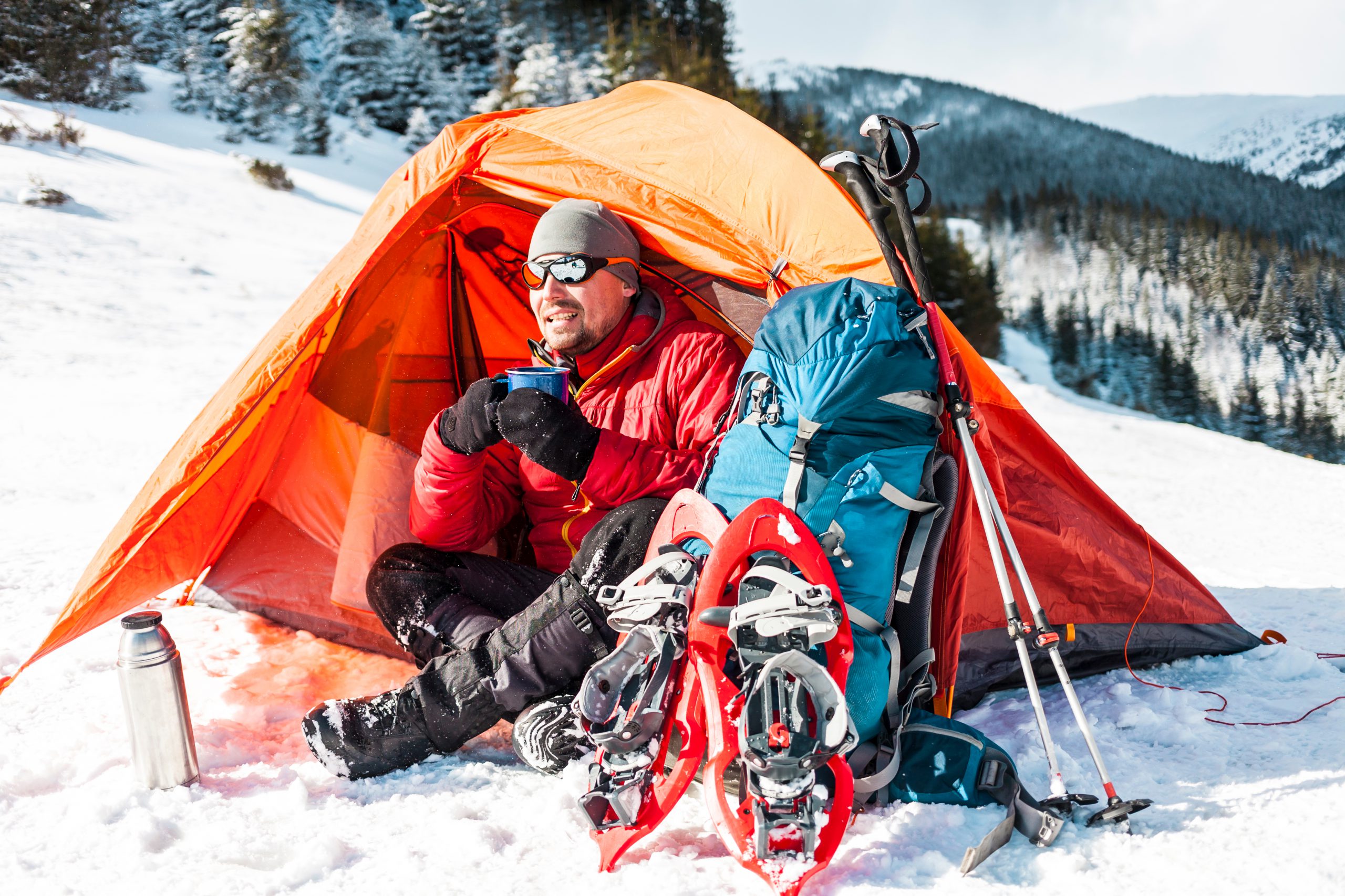 Man with winter camping equipment resting 